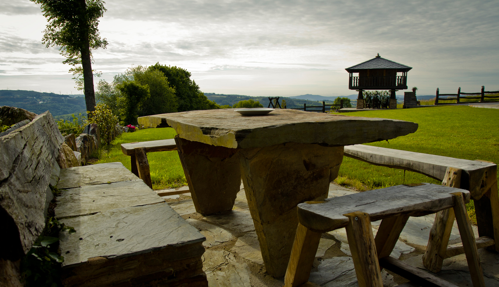 Mesa exterior con el horreo al fondo